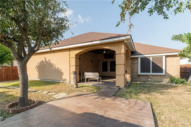 a view of a house with backyard and a tree