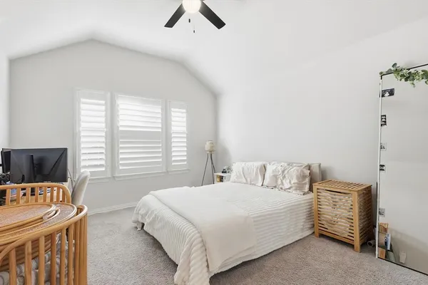 a bedroom with a bed and a flat tv screen on a dresser