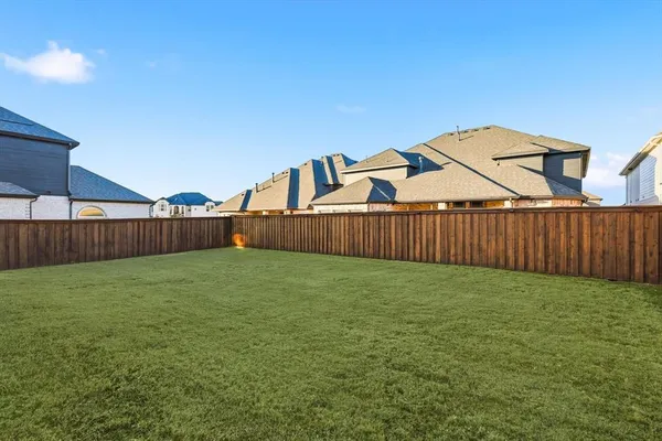a view of a backyard with wooden fence