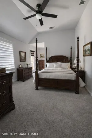 a spacious bedroom with a bed and a chandelier