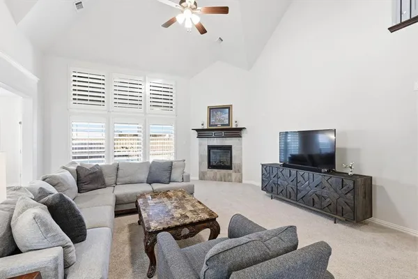 a living room with furniture a flat screen tv and a fireplace