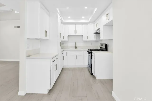 a kitchen with white cabinets appliances and sink