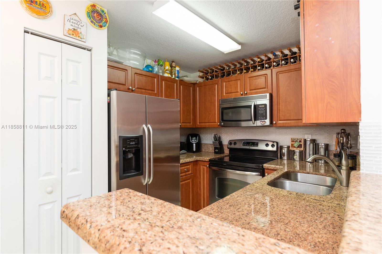 1068 Southwest 143rd Avenue, Unit 2510 Pembroke Pines, FL 33027 - Photo 12 of 49 a kitchen with granite countertop a refrigerator stove and microwave