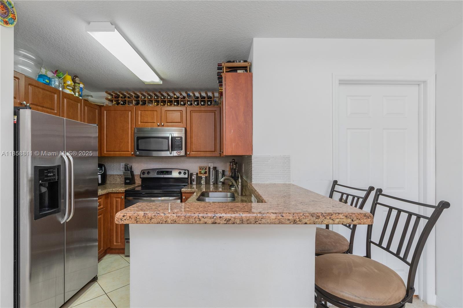1068 Southwest 143rd Avenue, Unit 2510 Pembroke Pines, FL 33027 - Photo 14 of 49 a kitchen with a refrigerator and a sink