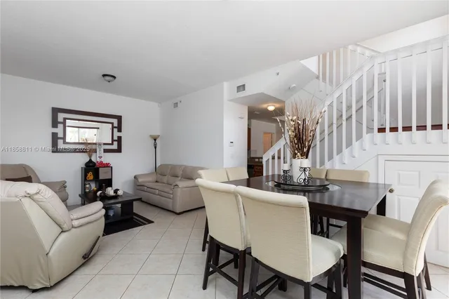 a living room with furniture a large window and a potted plant