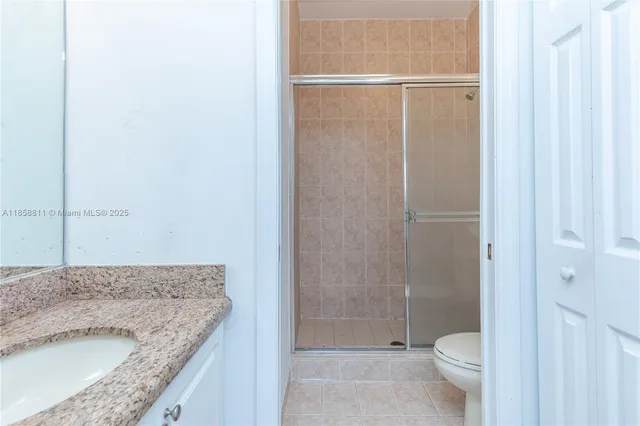 a bathroom with a granite countertop sink toilet and shower