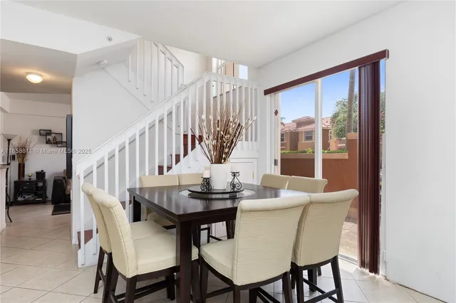a dining room with furniture a large window and potted plants