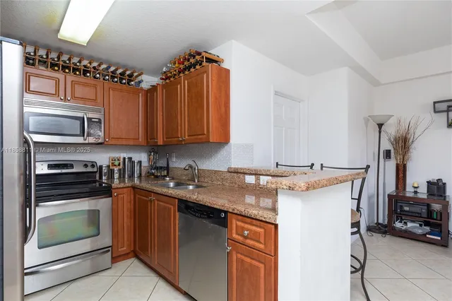 a kitchen with kitchen island granite countertop a sink stove and cabinets