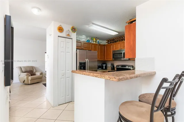 a kitchen with stainless steel appliances granite countertop a refrigerator and a stove