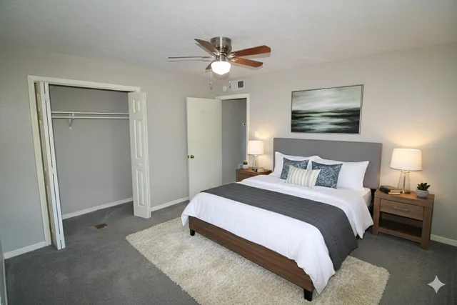 a bedroom with a bed and a ceiling fan