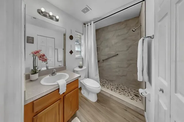 a bathroom with a granite countertop sink toilet and shower