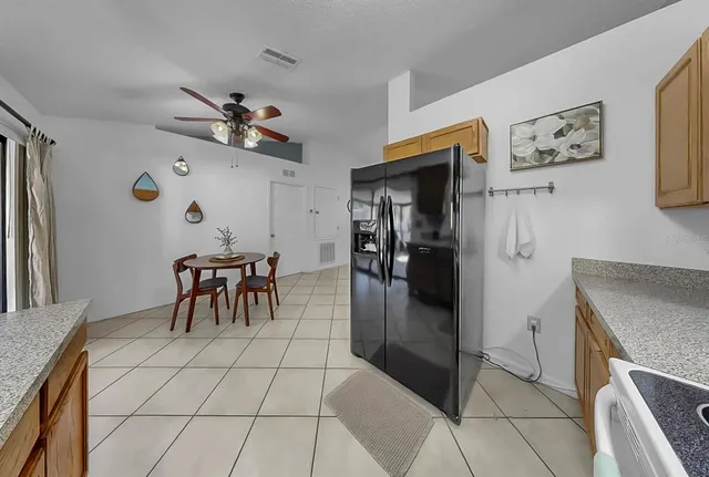 a dining room with stainless steel appliances kitchen island granite countertop furniture and a chandelier