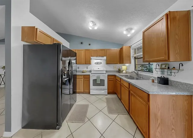 a kitchen with stainless steel appliances granite countertop a sink stove and cabinets