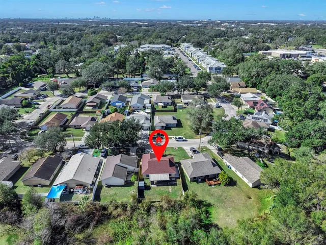 an aerial view of residential house with outdoor space and trees