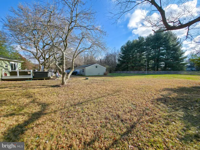 a view of a yard with a house and large trees