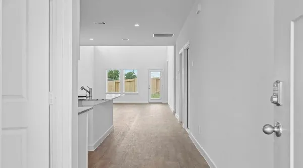 a view of a hallway with wooden floor and closet