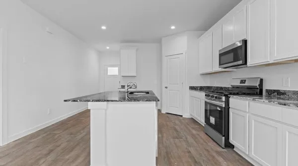 a kitchen with stainless steel appliances granite countertop a sink stove and microwave