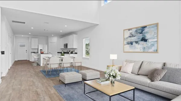 a living room with furniture and a view of kitchen