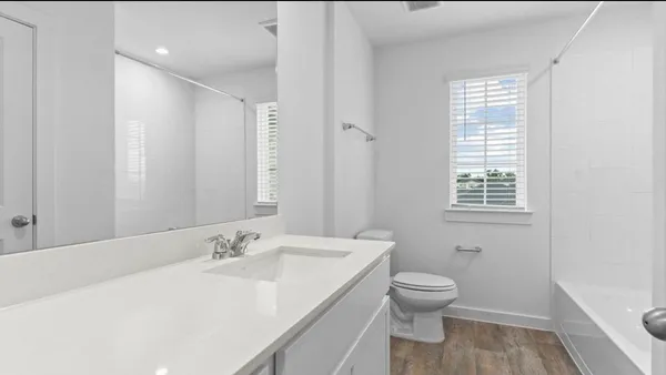 a bathroom with a granite countertop sink toilet a large mirror and shower