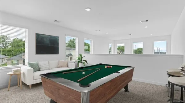 a room with pool table and windows