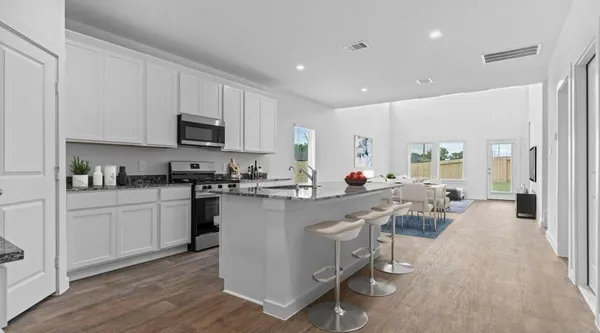 a kitchen with counter top space a sink appliances and cabinets
