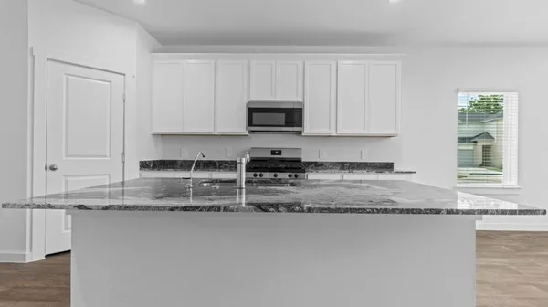 a kitchen with granite countertop a stove a sink and a granite counter tops