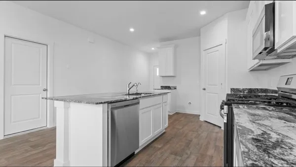 a kitchen with stainless steel appliances granite countertop a stove and a sink