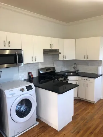 a kitchen with a sink a stove and cabinets