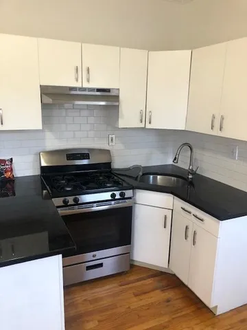 a kitchen with granite countertop a stove and a sink