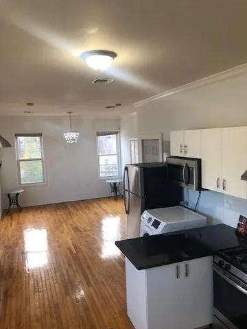 a kitchen with a counter space a sink appliances and wooden floor