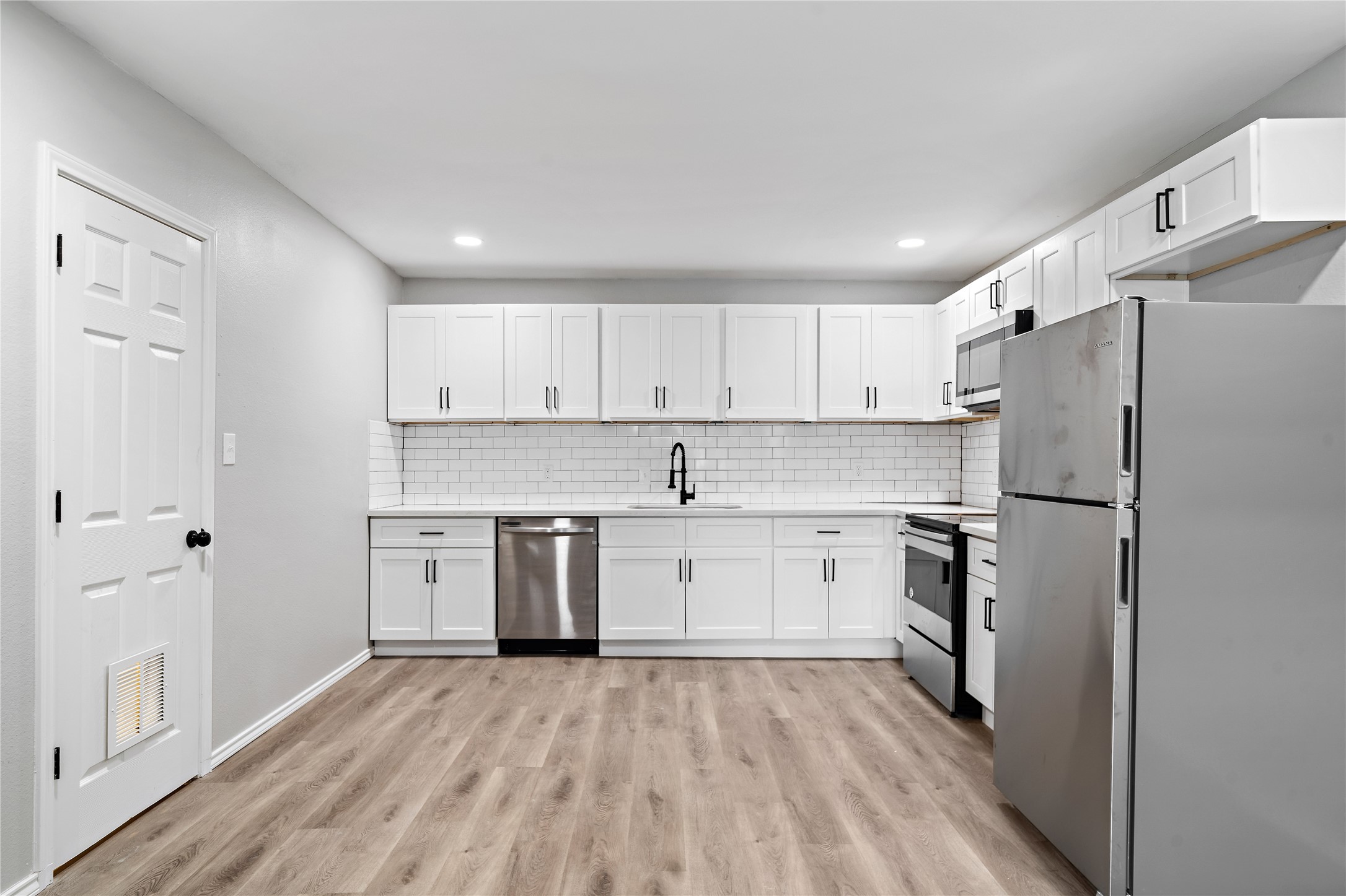 9711 Linkmeadow Lane, Unit 17 Houston, TX 77025 - Photo 1 of 15 a kitchen with a refrigerator a sink and dishwasher with wooden floor