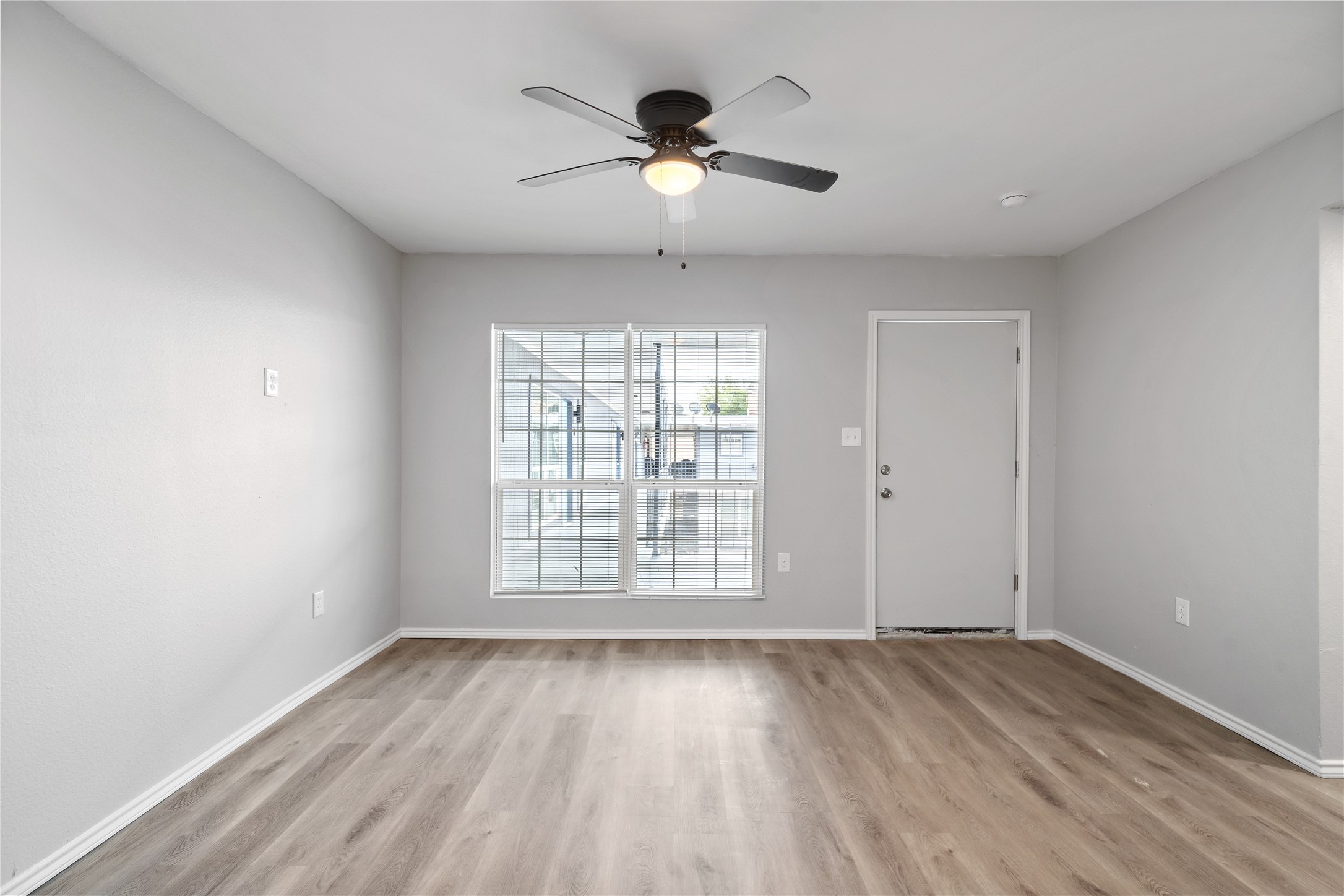 9711 Linkmeadow Lane, Unit 17 Houston, TX 77025 - Photo 2 of 15 an empty room with wooden floor and windows
