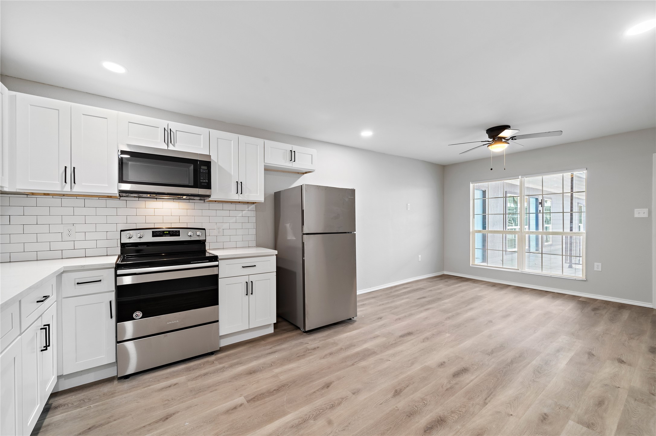 9711 Linkmeadow Lane, Unit 17 Houston, TX 77025 - Photo 8 of 15 a kitchen with a stove a microwave and a refrigerator