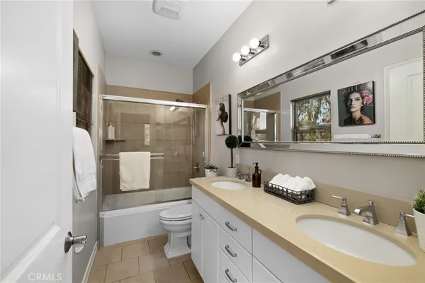 a bathroom with a granite countertop bathtub sink mirror vanity toilet and shower