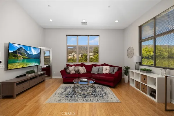 a living room with furniture flat screen tv and a large window