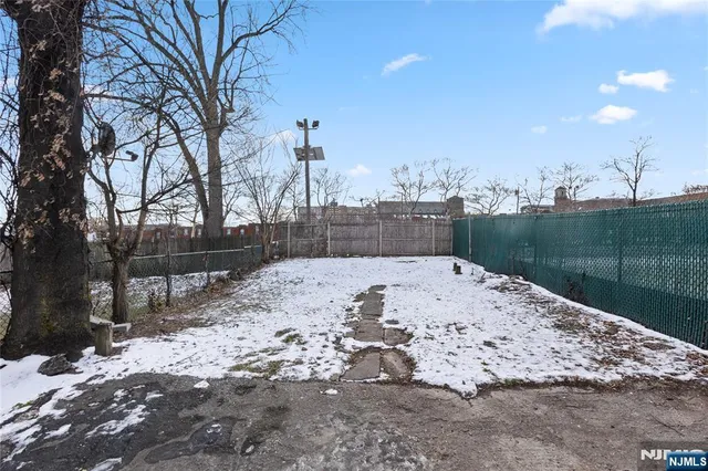 an empty room with wooden floor closet and windows