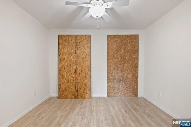 an empty room with wooden floor and closet