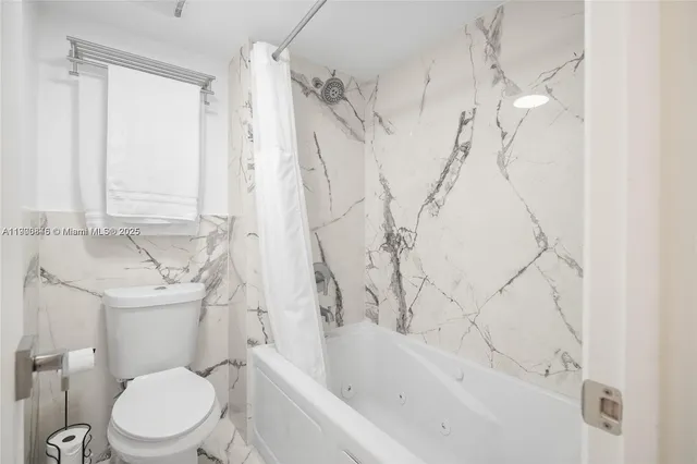 a white toilet sitting next to a bath tub shower