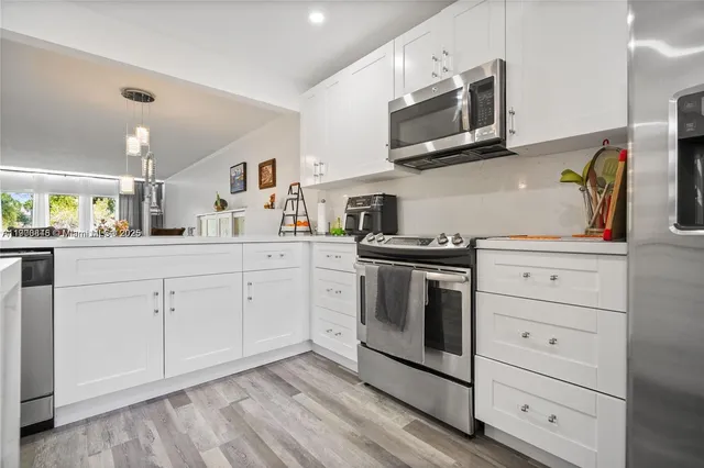 a kitchen with stainless steel appliances white cabinets and a sink