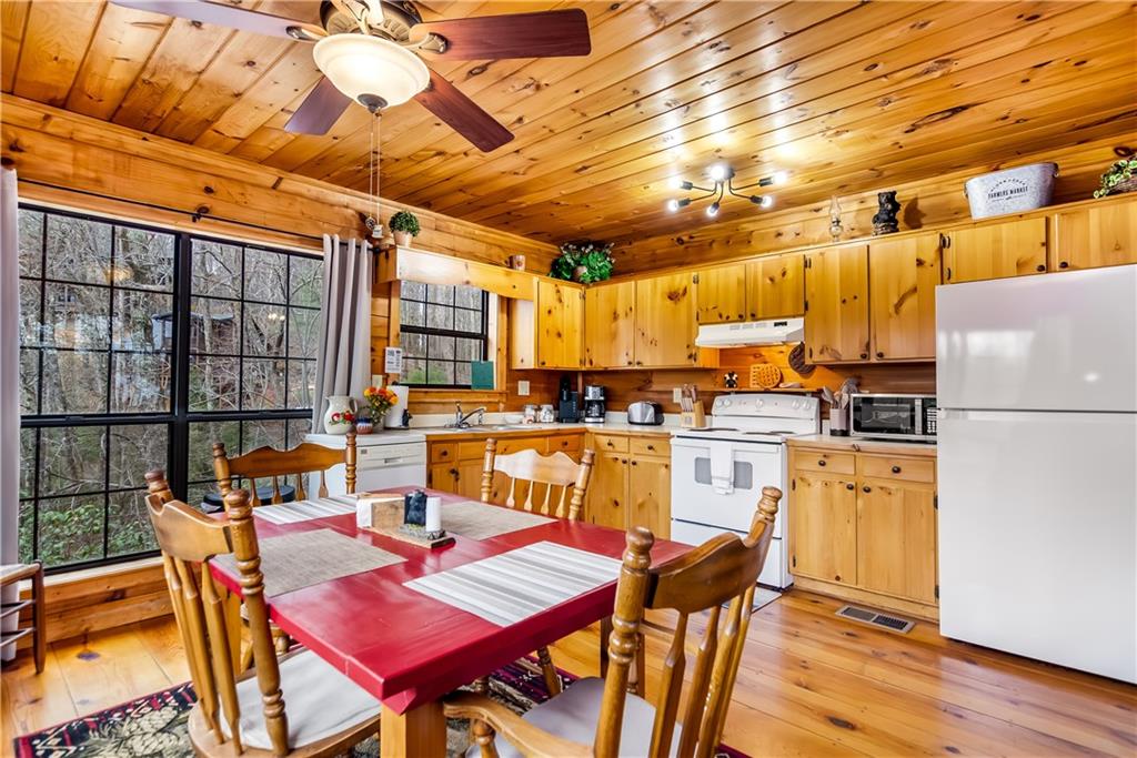 152 Broken Arrow Path Blue Ridge, GA 30513 - Photo 18 of 50 a open kitchen with stainless steel appliances granite countertop a stove a refrigerator a dining table and chairs with wooden floor