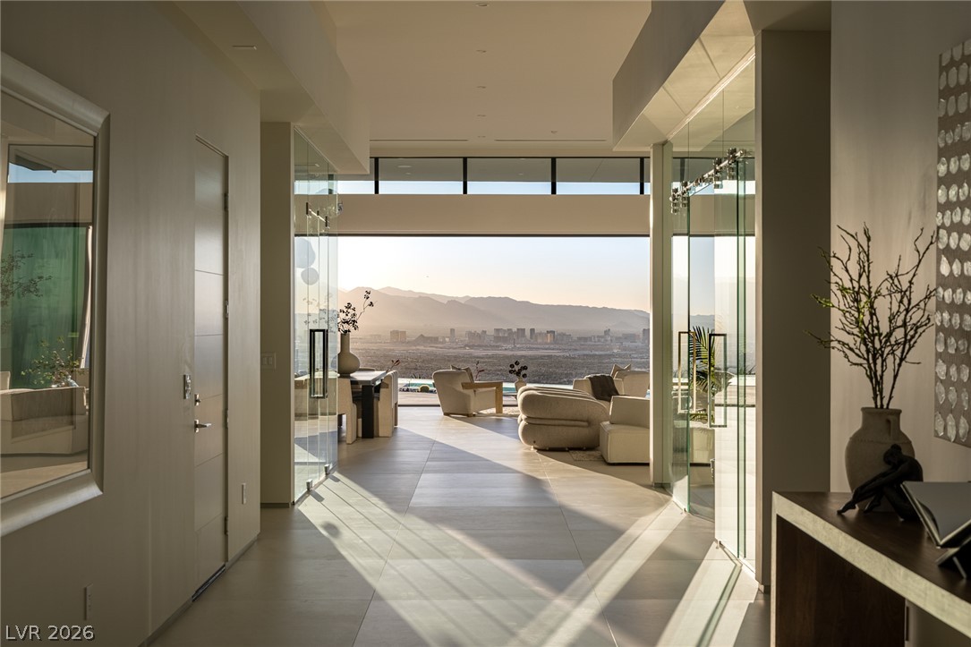 563 Grand Rim Drive Henderson, NV 89012 - Photo 3 of 70 Floor-to-ceiling windows showcase an awe-inspiring cityscape and mountain views from this inviting living area.