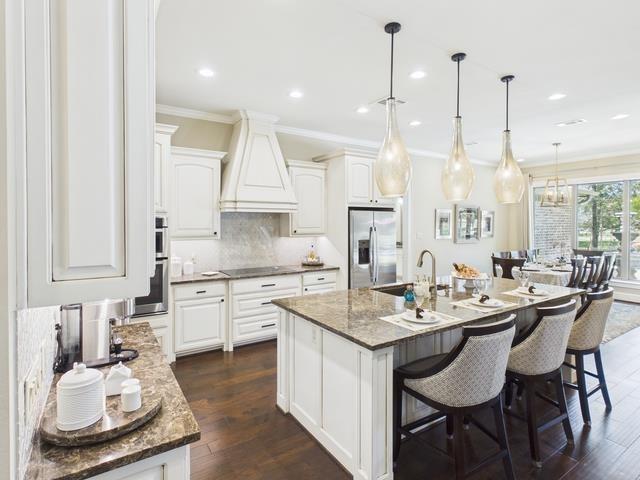 8550 Toler Pointe Larue, TX 75770 - Photo 27 of 37 a kitchen with a sink stove and white cabinets with wooden floor