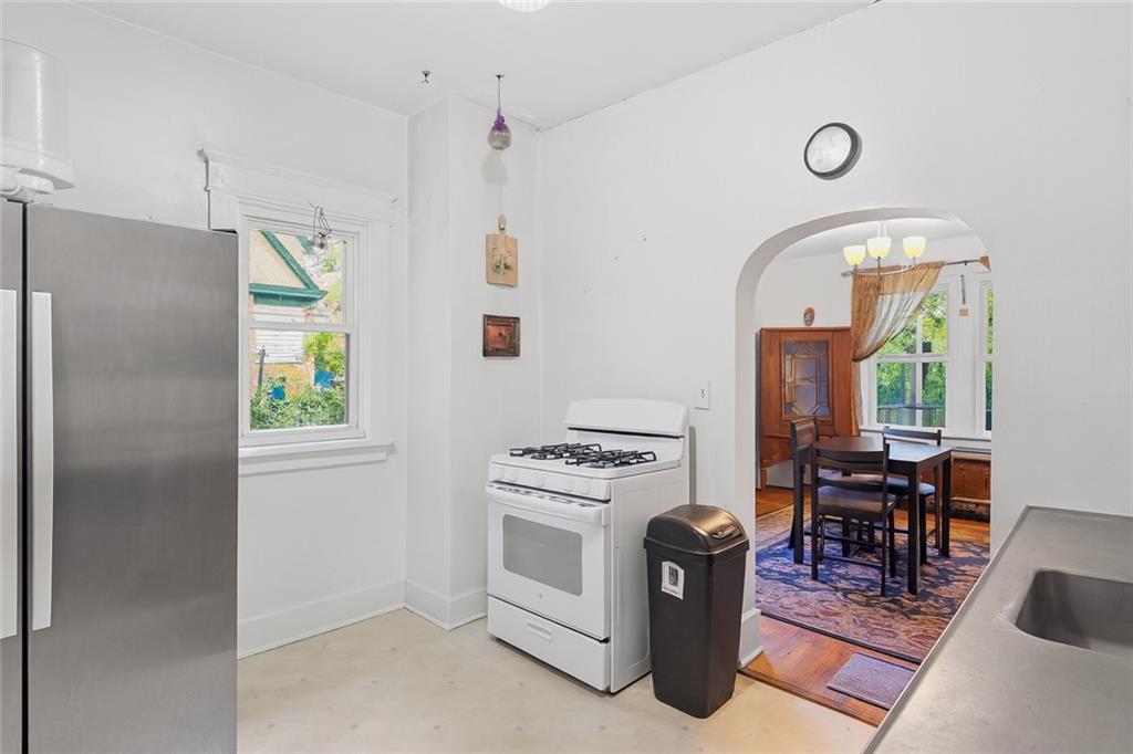 288 Bascom Avenue Pittsburgh, PA 15214 - Photo 13 of 32 a kitchen with a stove a refrigerator and a dining table