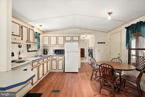 a kitchen with stainless steel appliances granite countertop a white cabinets and wooden floors