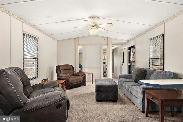 a living room with furniture a chandelier and a window