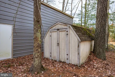 a view of a house with a large window and wooden fence