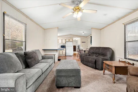 a living room with furniture ceiling fan and a window