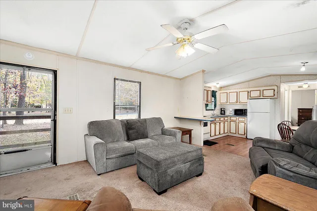a living room with furniture and a ceiling fan