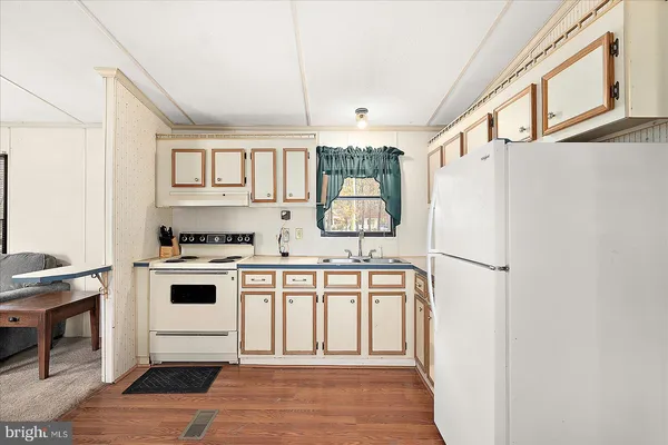 a white kitchen with a stove a refrigerator and a stove