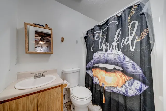 a bathroom with a toilet sink and mirror